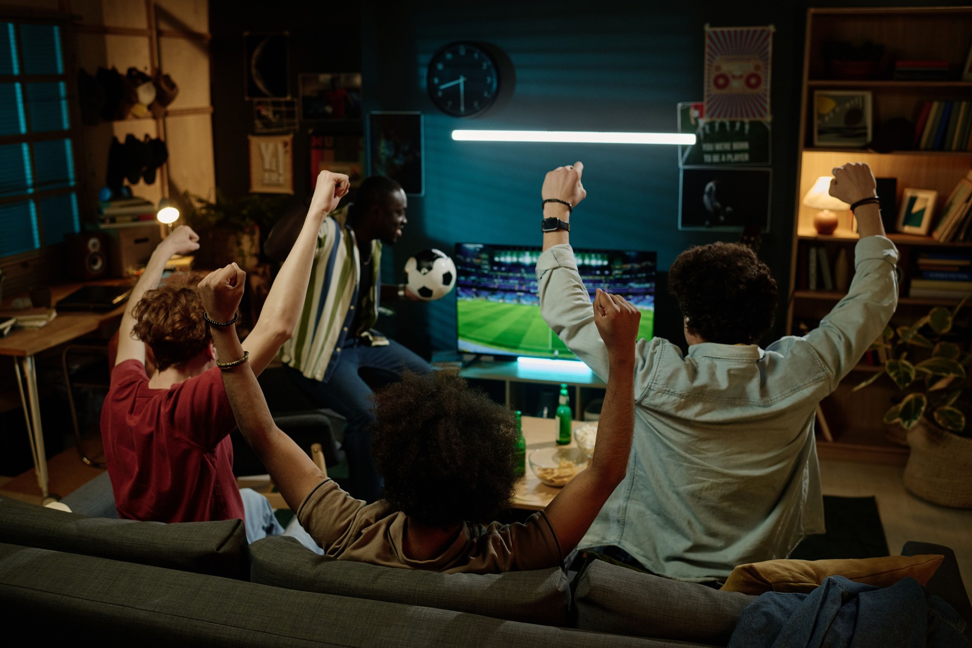 Friends Having Fun Watching Soccer Game On TV