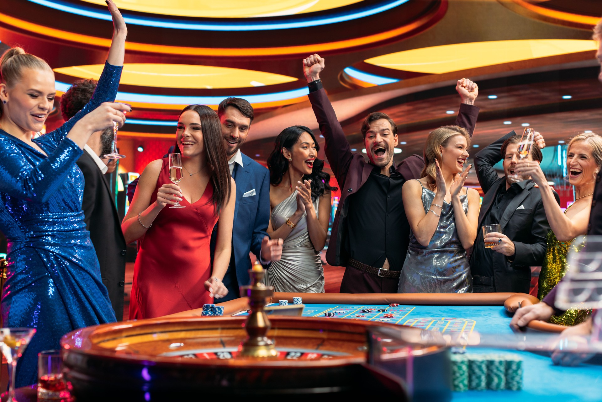Group of Diverse Young People Gambling at a Casino. Beautiful Female and Handsome Male Guests Placing Risky Bets while Playing Roulette. Crowd Celebrating a Positive Outcome and Cheering the Winner